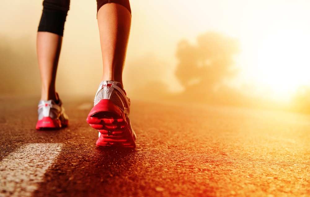 Athlete runner feet running on road closeup on shoe. woman fitne