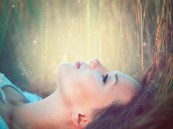 Beauty Romantic Girl lying on the Field and dreaming. Beautiful
