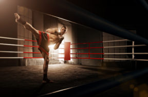 Young man kickboxing in the Arena