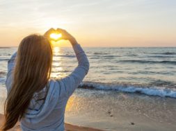 Girl Holding Hands In Heart Shape At Beach