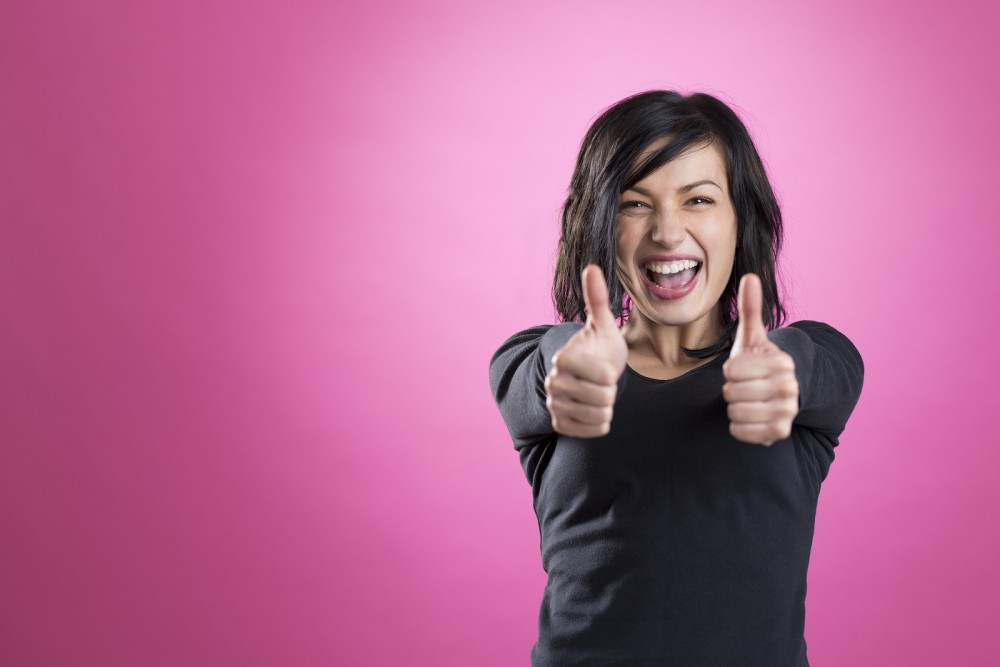 Excited, happy girl giving thumbs up showing success, isolated o