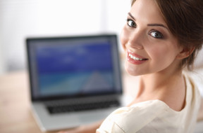 Portrait of beautiful young business woman working on a laptop a