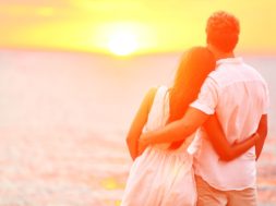 Honeymoon couple romantic in love at beach sunset. Newlywed happ