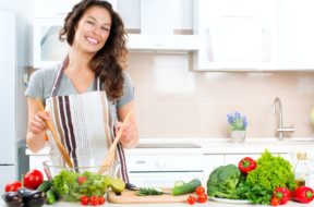 Young Woman Cooking in the kitchen. Healthy Food – Vegetable Sal