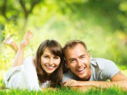 Happy Smiling Couple Together Relaxing on Green Grass. Park. You