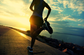 Runner athlete running at seaside. woman fitness silhouette sunr