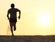 Back View Silhouette Of A Runner Man Running On The Beach